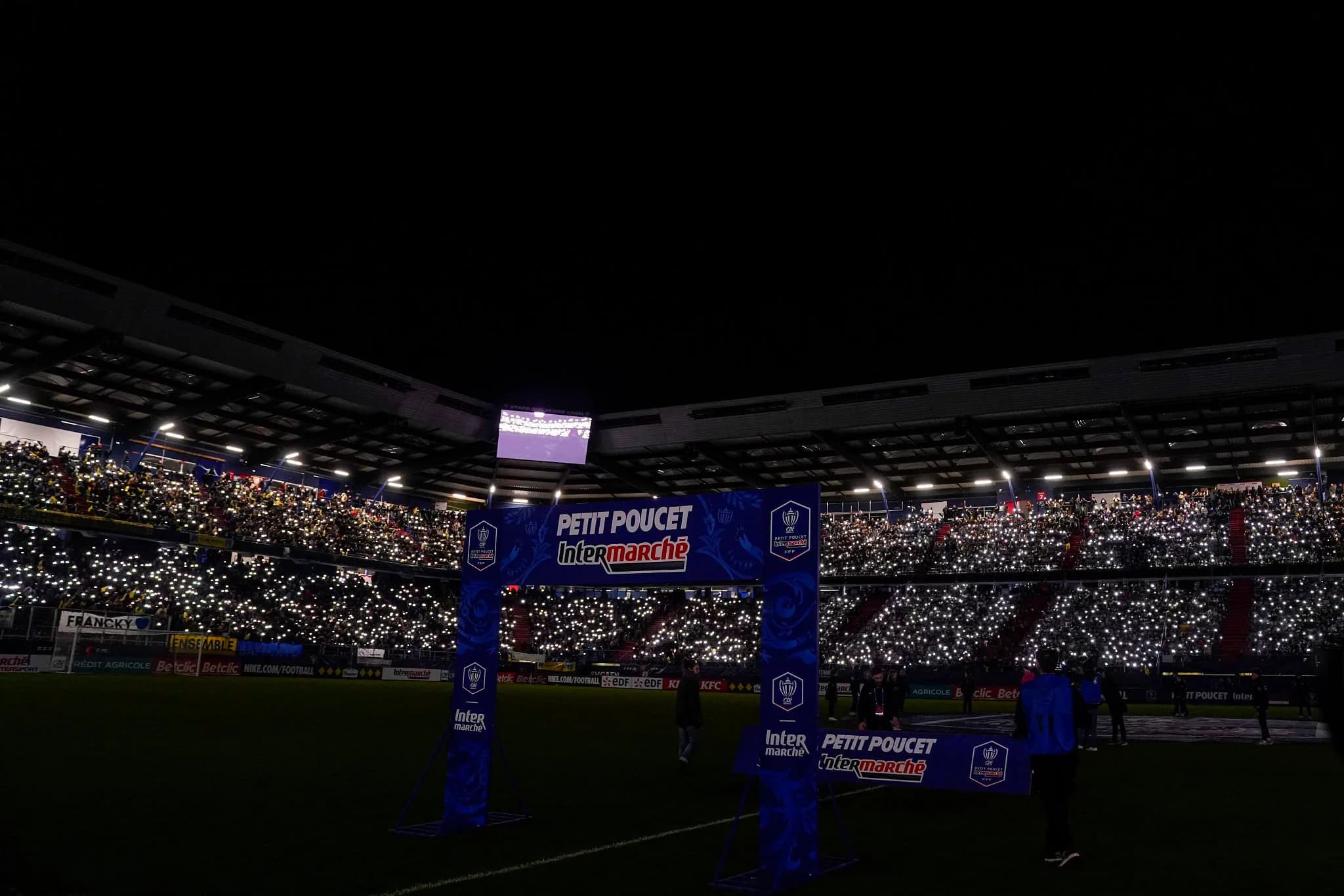 Le stade Michel d'Ornano illuminé par les téléphones des supporters, avant Bayeux FC contre l'Olympique de Marseille